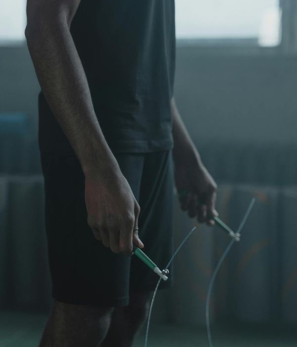 Man performing a strength exercise in a dark modern gym.